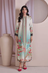 Woman wearing a floral dress with a decorative border in a minimalistic setting.