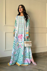 Woman wearing a colorful floral dress against a beige wall.