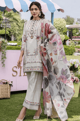 Woman in a floral outfit with a matching dupatta at an outdoor event.