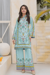 Woman wearing a light blue outfit with colorful patterns in an indoor setting.