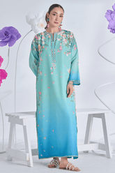 Woman wearing a light blue dress with floral patterns in a decorative setting with flowers.