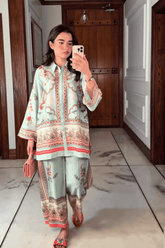 Woman taking a mirror selfie wearing a traditional outfit in a hallway.