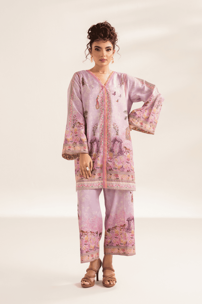 Woman wearing a pink printed outfit on a white background