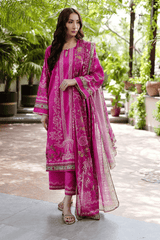 Woman wearing a pink traditional outfit with intricate patterns in an outdoor setting.