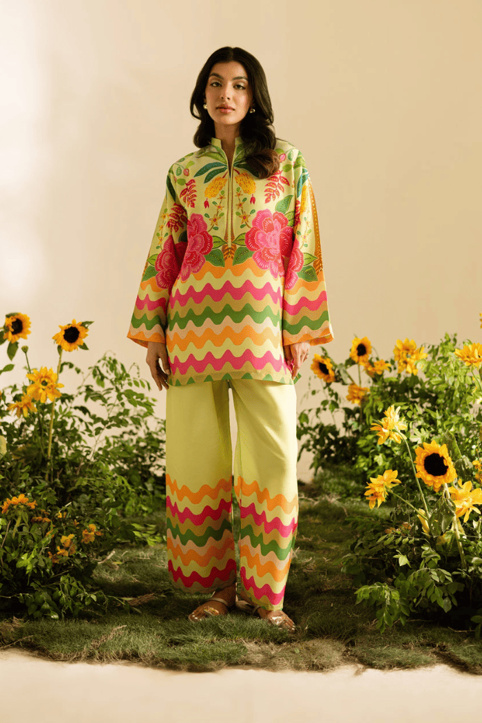 Woman in a colorful outfit standing in a garden with sunflowers