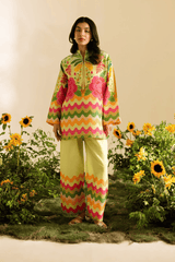 Woman in a colorful outfit standing in a garden with sunflowers