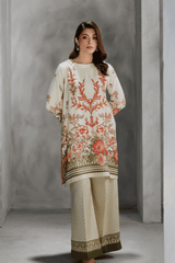 Woman wearing a cream embroidered outfit against a gray background