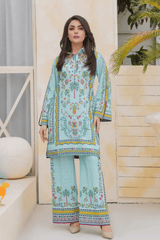 Woman wearing a light blue  outfit with colorful patterns in an indoor setting.