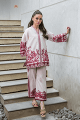Woman in a traditional outfit with red standing on stone steps.
