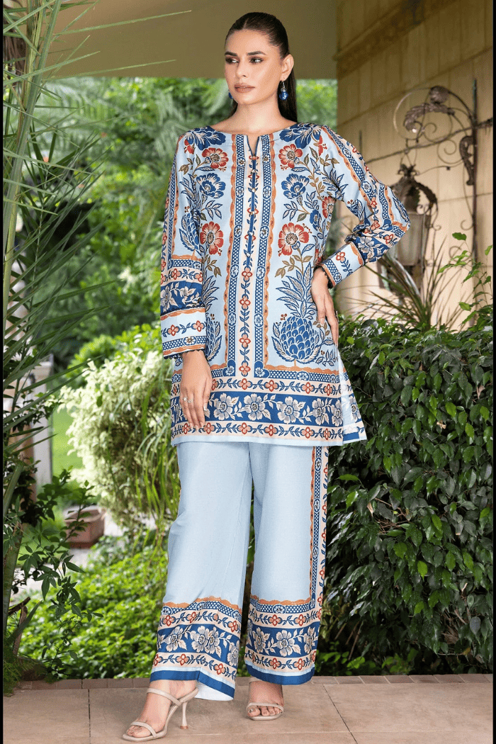 Woman wearing a patterned kurta with light blue pants in an outdoor setting.
