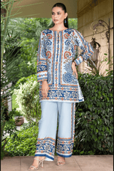 Woman wearing a patterned kurta with light blue pants in an outdoor setting.