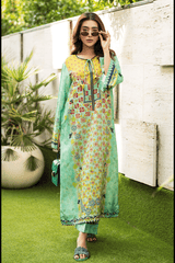 Woman wearing a green floral dress with a yellow top in an outdoor setting.