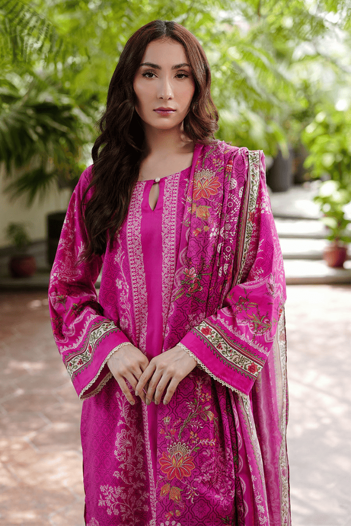 Woman wearing a pink traditional outfit with a green outdoor background