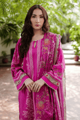 Woman wearing a pink traditional outfit with a green outdoor background