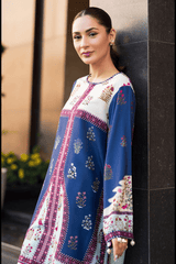 Woman wearing a blue and white dress leaning against a wall.