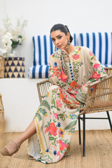Woman in a floral dress sitting on a chair in a room with a blue and white striped curtain.