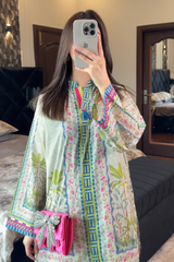 Person wearing a colorful floral dress in a bedroom setting