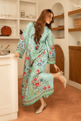 Woman in a floral dress standing in a kitchen.