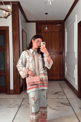 Woman taking a mirror selfie in a room with wooden doors and white walls.