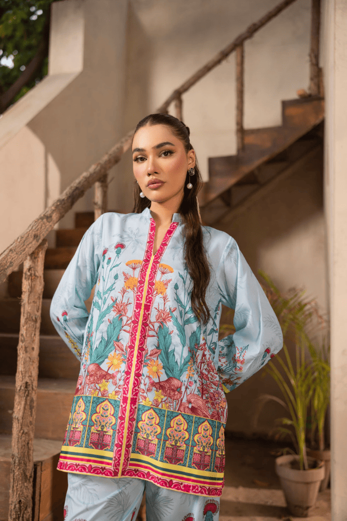 Woman wearing a colorful traditional outfit standing on a staircase.