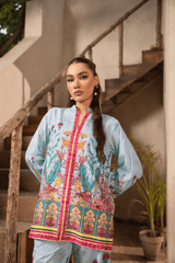 Woman wearing a colorful traditional outfit standing on a staircase.