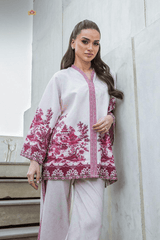 Woman wearing a white outfit with pink floral  against a light gray background