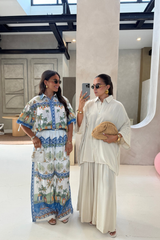 Two women taking a mirror selfie in a stylish setting.