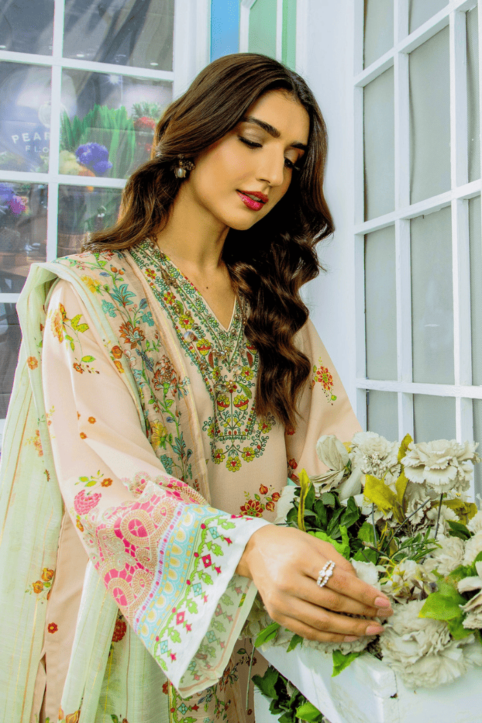 Woman in a floral outfit holding flowers indoors.