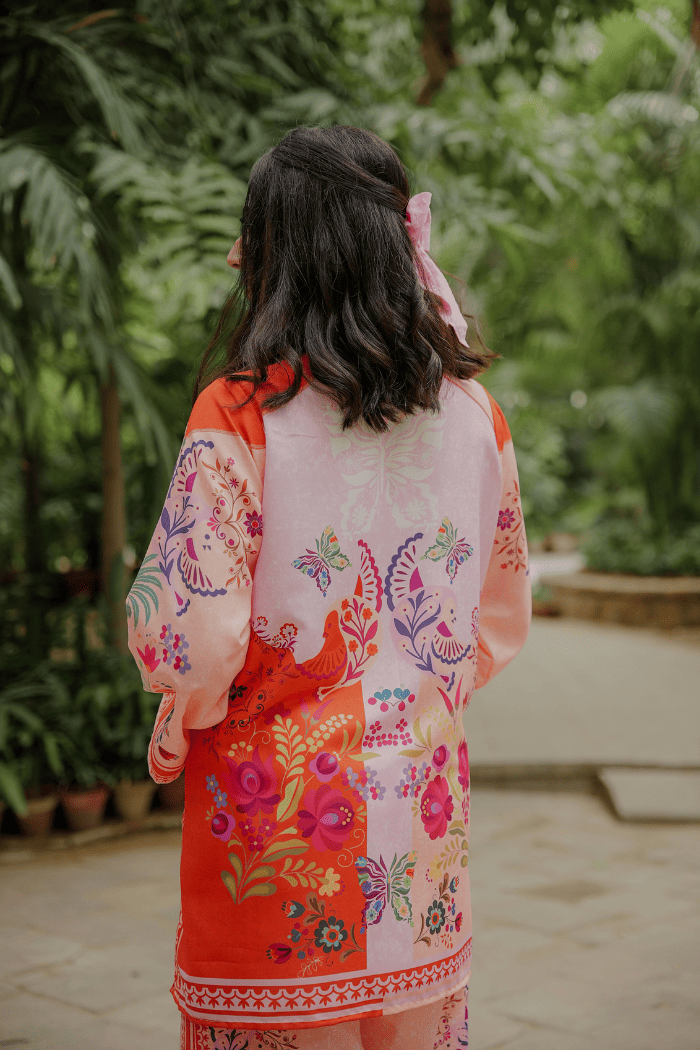 Person wearing a colorful floral kimono in a garden setting