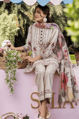 Woman in traditional outfit with floral patterns sitting outdoors