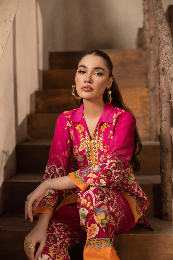 Woman in a vibrant traditional outfit sitting on a staircase.