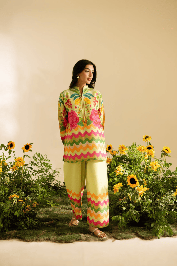 Woman in colorful outfit standing in a garden with sunflowers