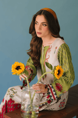 Woman in a colorful traditional outfit holding sunflowers against a blue background