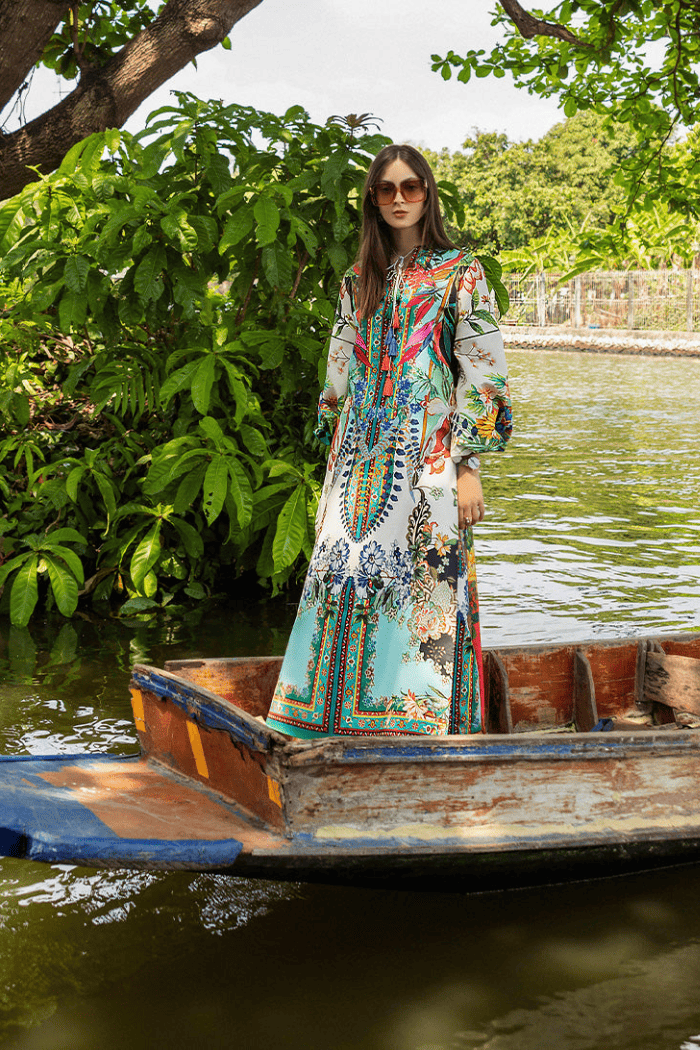 Woman in a colorful dress standing in a boat on a river with greenery around