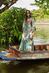 Woman in a colorful dress standing in a boat on a river with greenery around
