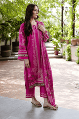 Woman wearing a pink traditional outfit with embroidery in an outdoor setting.