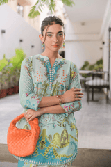 Woman wearing a floral dress with an orange handbag indoors