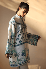 Woman wearing a patterned shirt with palm tree design against a plain background