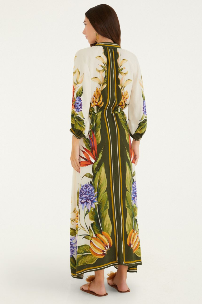 Woman wearing a long, floral-patterned dress on a white background