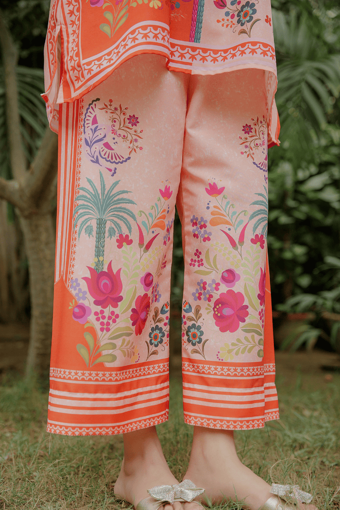 Colorful pants with a floral and geometric pattern on a blurred natural background