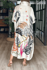 Long, patterned dress with flamingo design worn by a person indoors.