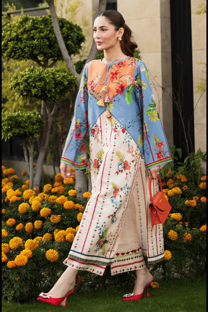Woman in a colorful traditional outfit standing in front of flowers