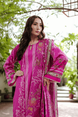 Woman wearing a pink traditional outfit with a green outdoor background