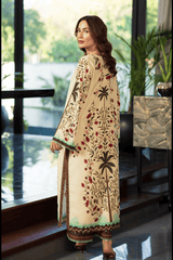 Woman wearing a cream-colored embroidered outfit standing indoors with plants in the background