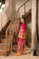 Woman in a vibrant traditional outfit standing on a staircase outdoors