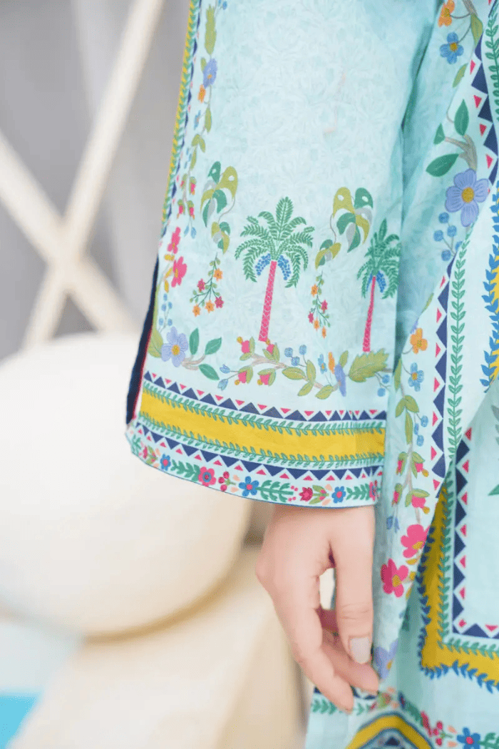 Close-up of a colorful garment with palm tree and floral patterns.