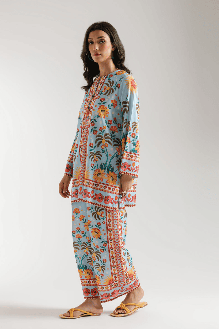 Woman wearing a colorful traditional outfit with a floral pattern on a white background