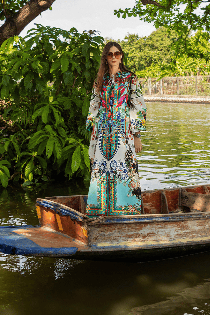 Woman in a colorful dress standing in a boat on a river with greenery around