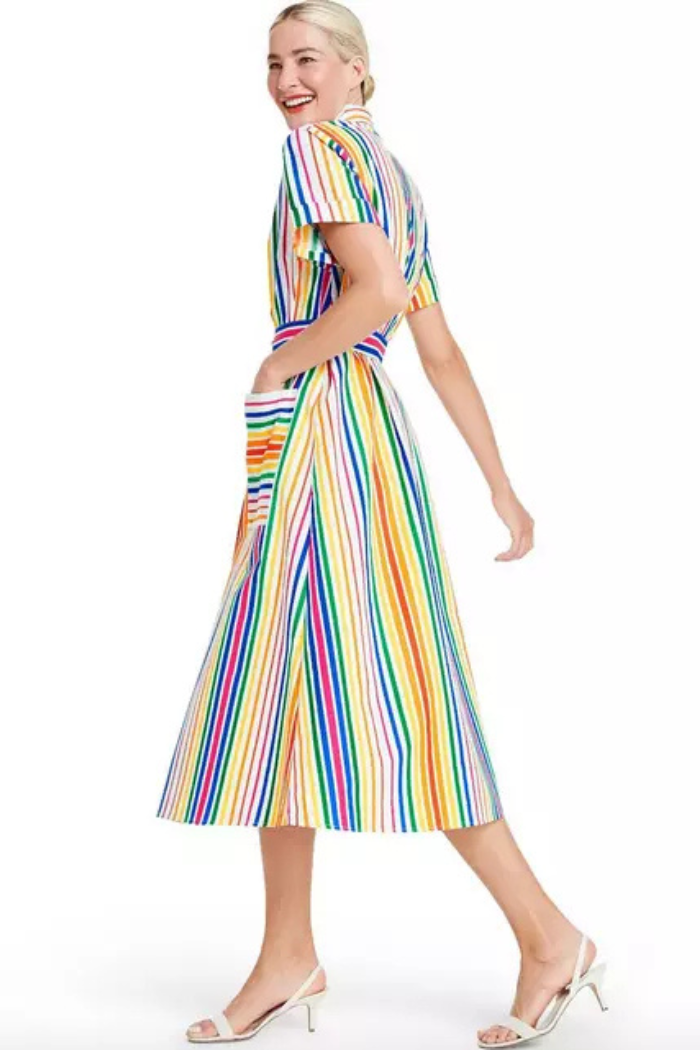 Woman wearing a colorful striped dress on a white background