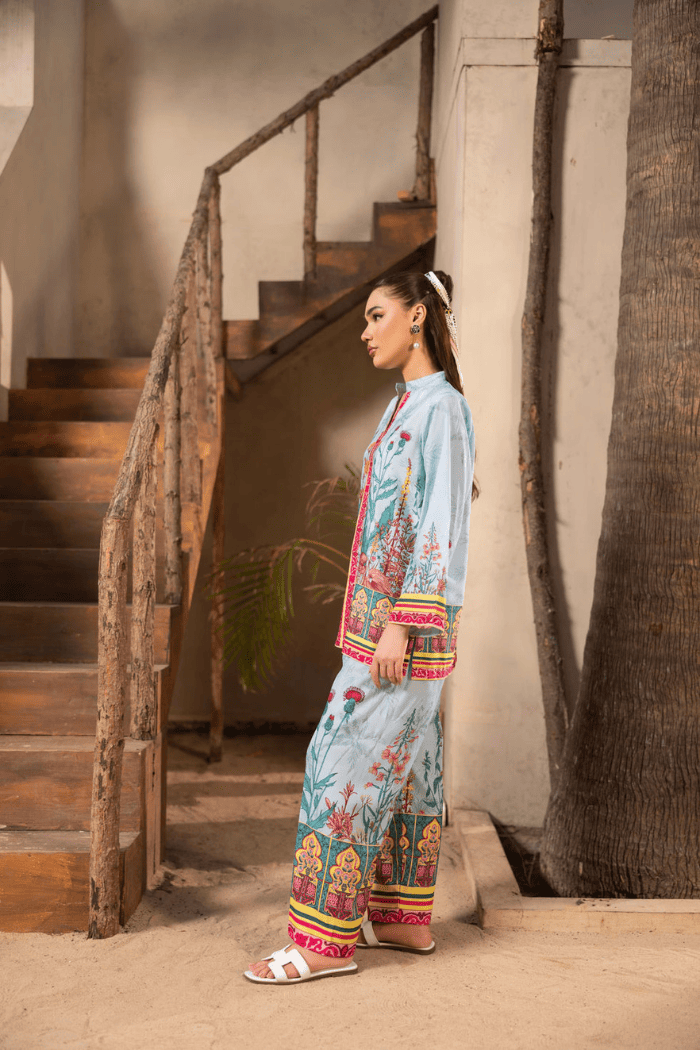 Woman in a colorful traditional outfit standing near a staircase.
